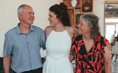 Shir Siegel, center, is embraced by her parents, former hostages Keith, left, and Aviva at Shir's wedding on August 7, 2025. (Paulina Patimer)